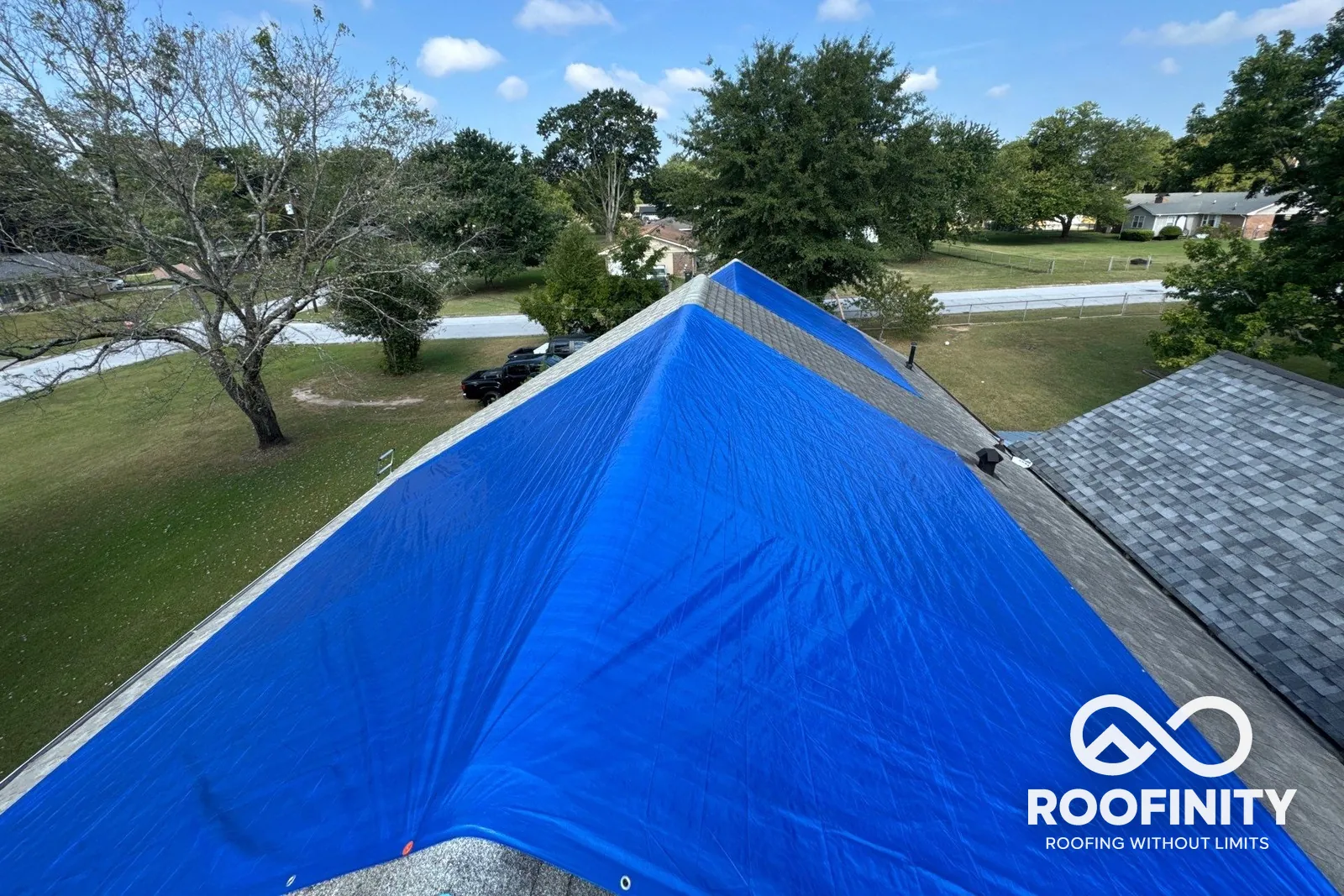 Blue emergency tarp installed by Roofinity on a damaged roof
