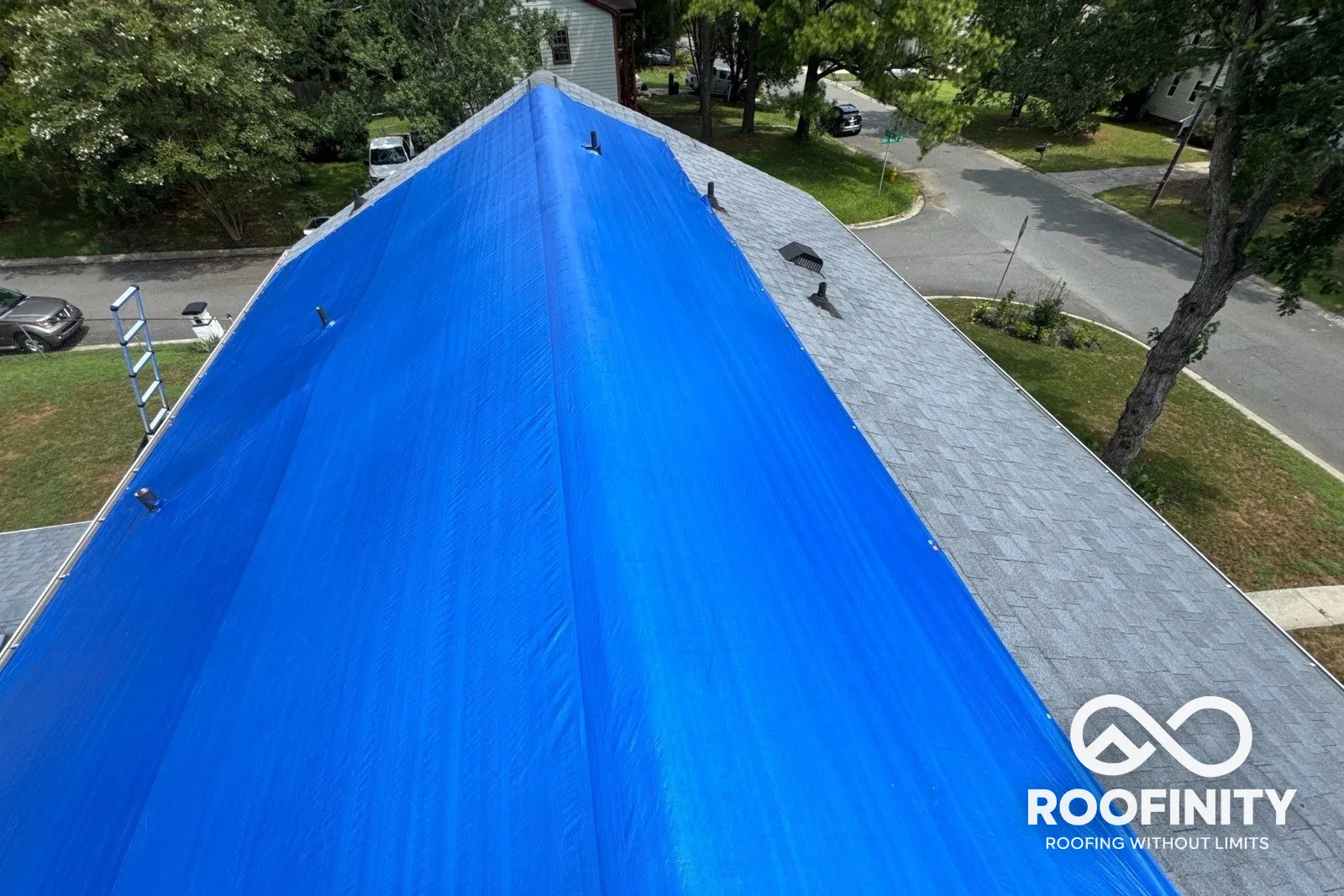 Roofinity emergency roof tarp secured to shingle roof